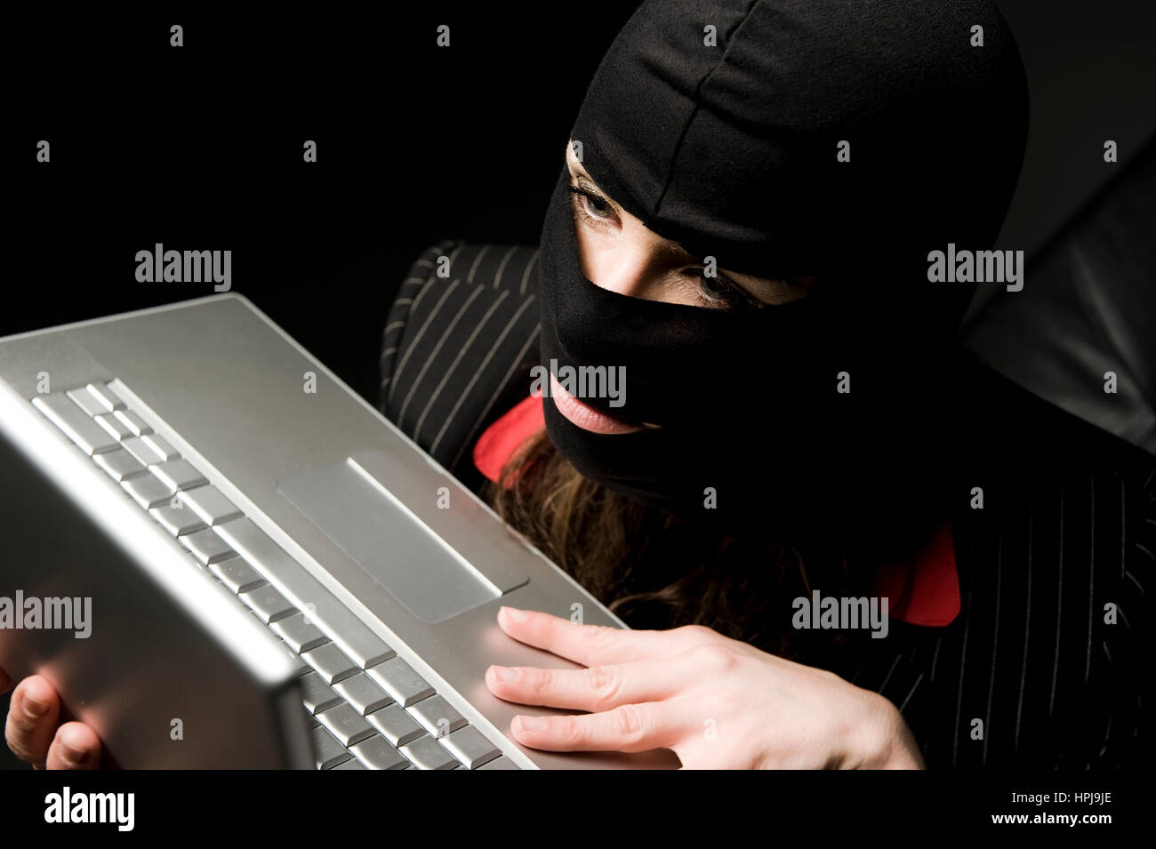 Model released , Einbrecherin mit Laptop, Wirtschaftsspionage - symbolic for data piracy Stock Photo