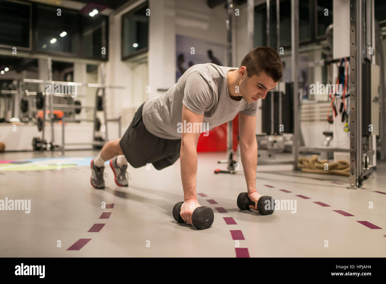 Young man doing push-ups in the gym Stock Photo - Alamy