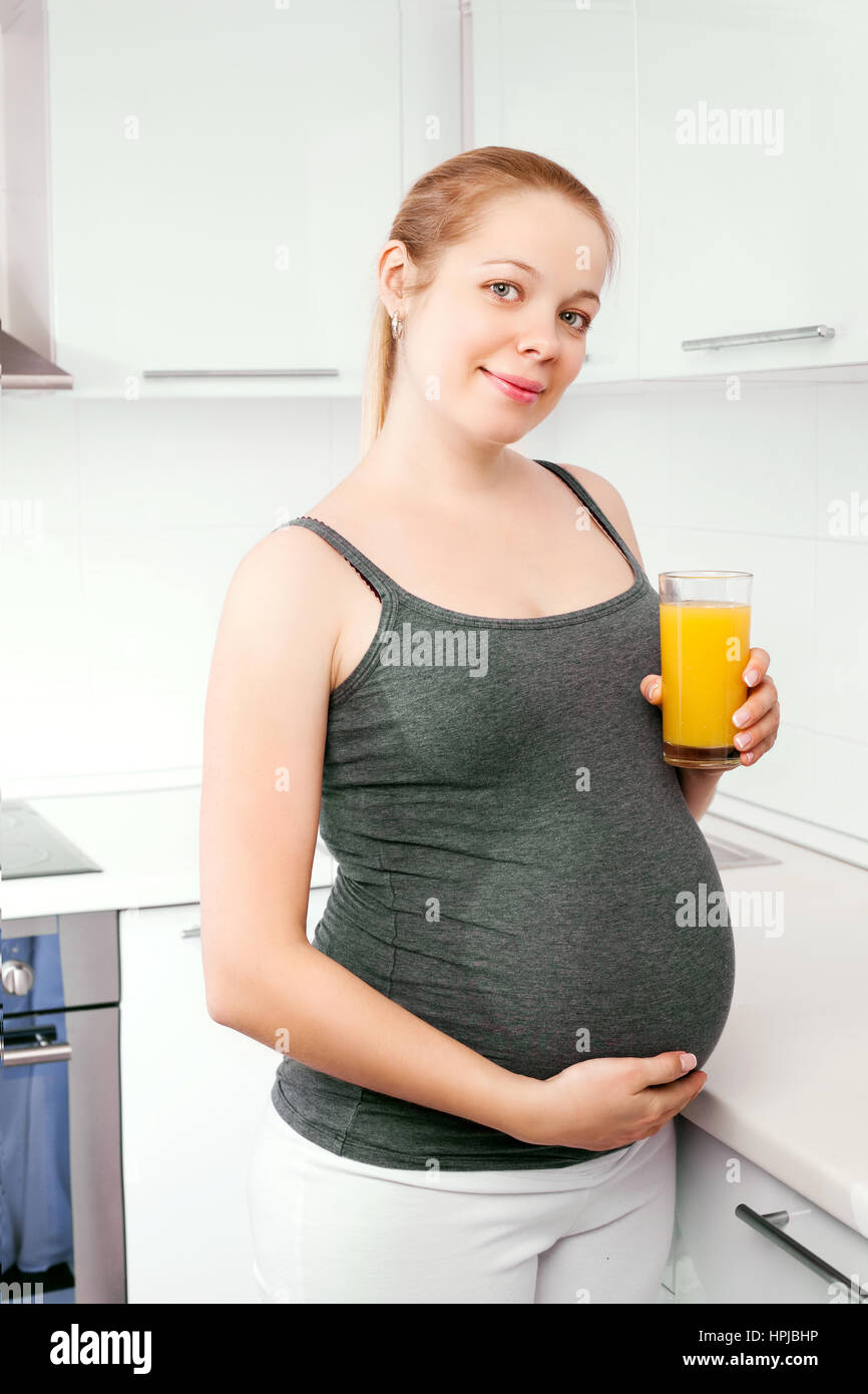 pregnant woman drinking orange juice at home Stock Photo Alamy