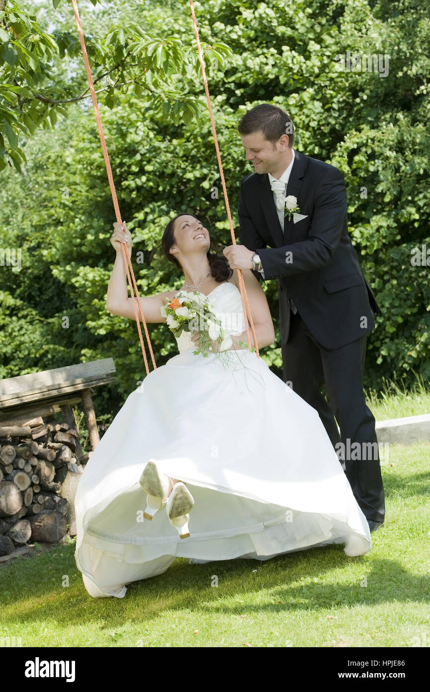 Model released , Brautpaar auf Schaukel - bridal couple on a swing Stock Photo