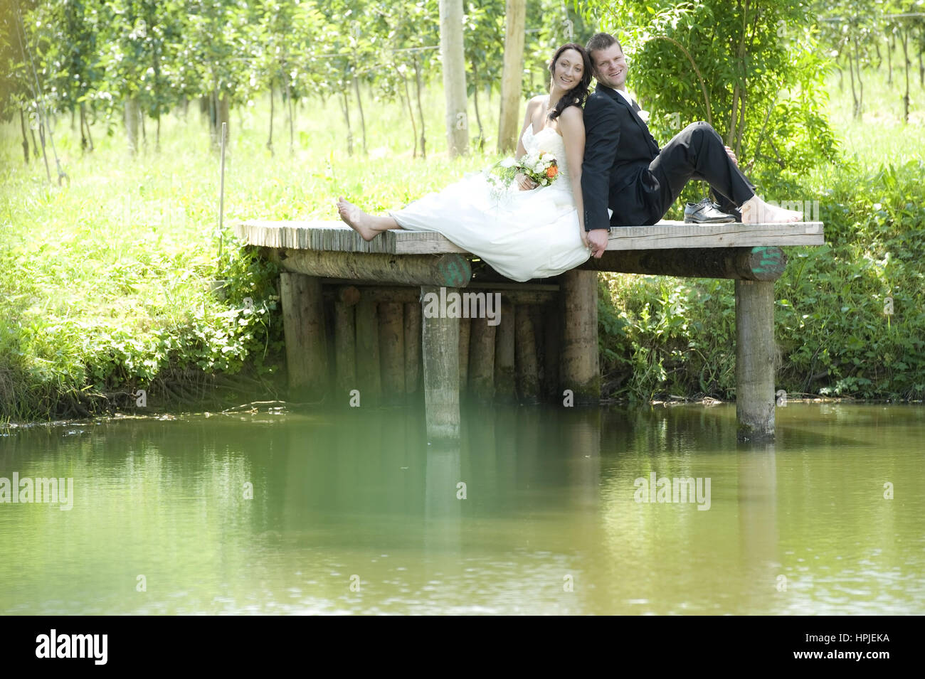 Model released , Brautpaar auf Steg am Teich - bridal couple Stock Photo