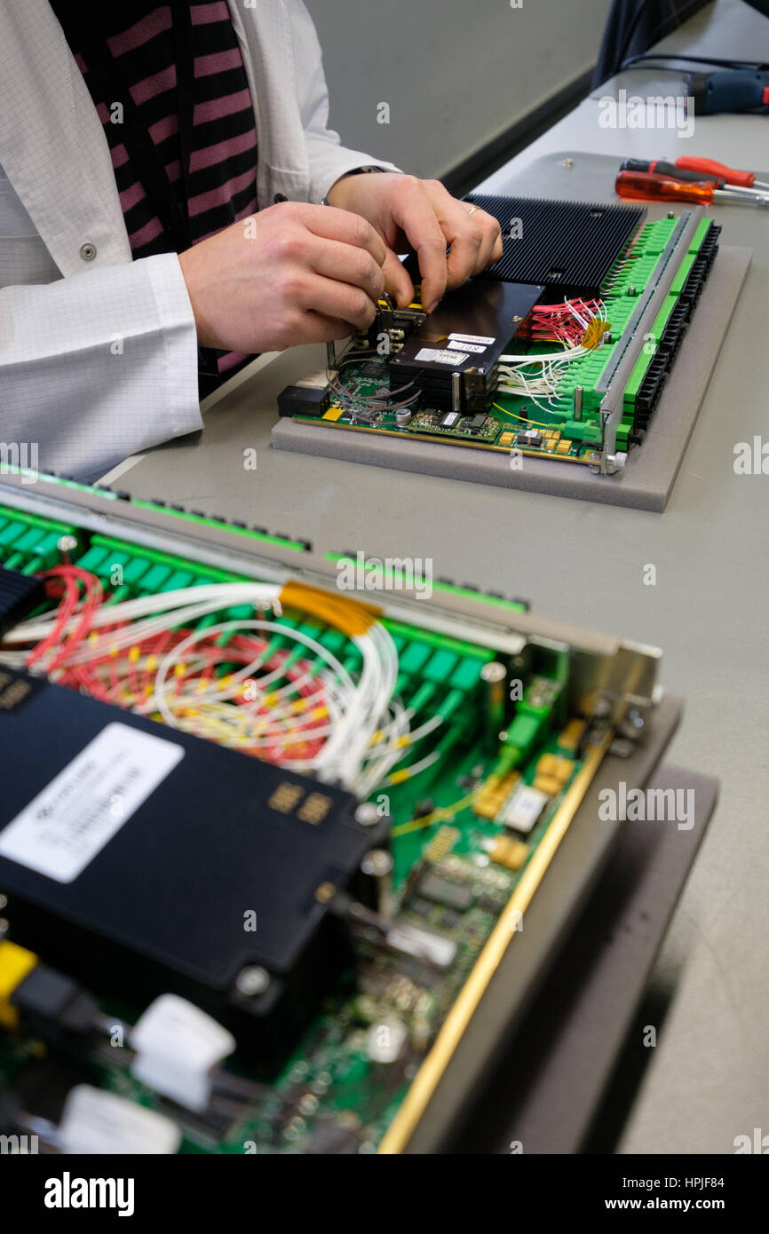 Worker assembling an electronic device at a factory Stock Photo