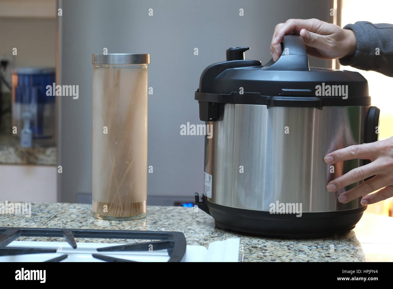 A pair of hands opening a pressure cooker Stock Photo Alamy