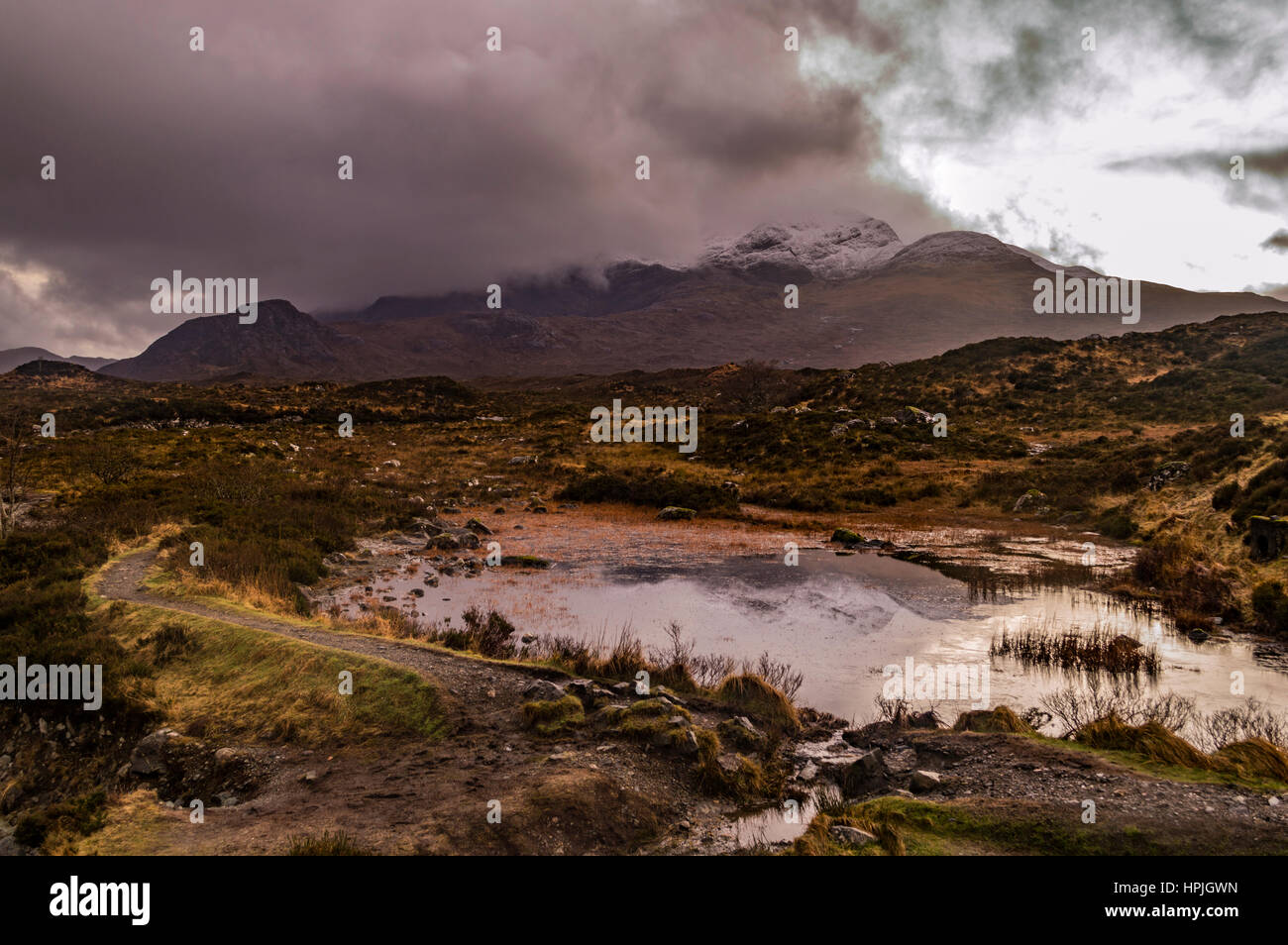 Snowcapped Cuillin Hills reflected in water at Sligachan, shrouded in clouds, on the Isle of Skye, Scotland. Stock Photo