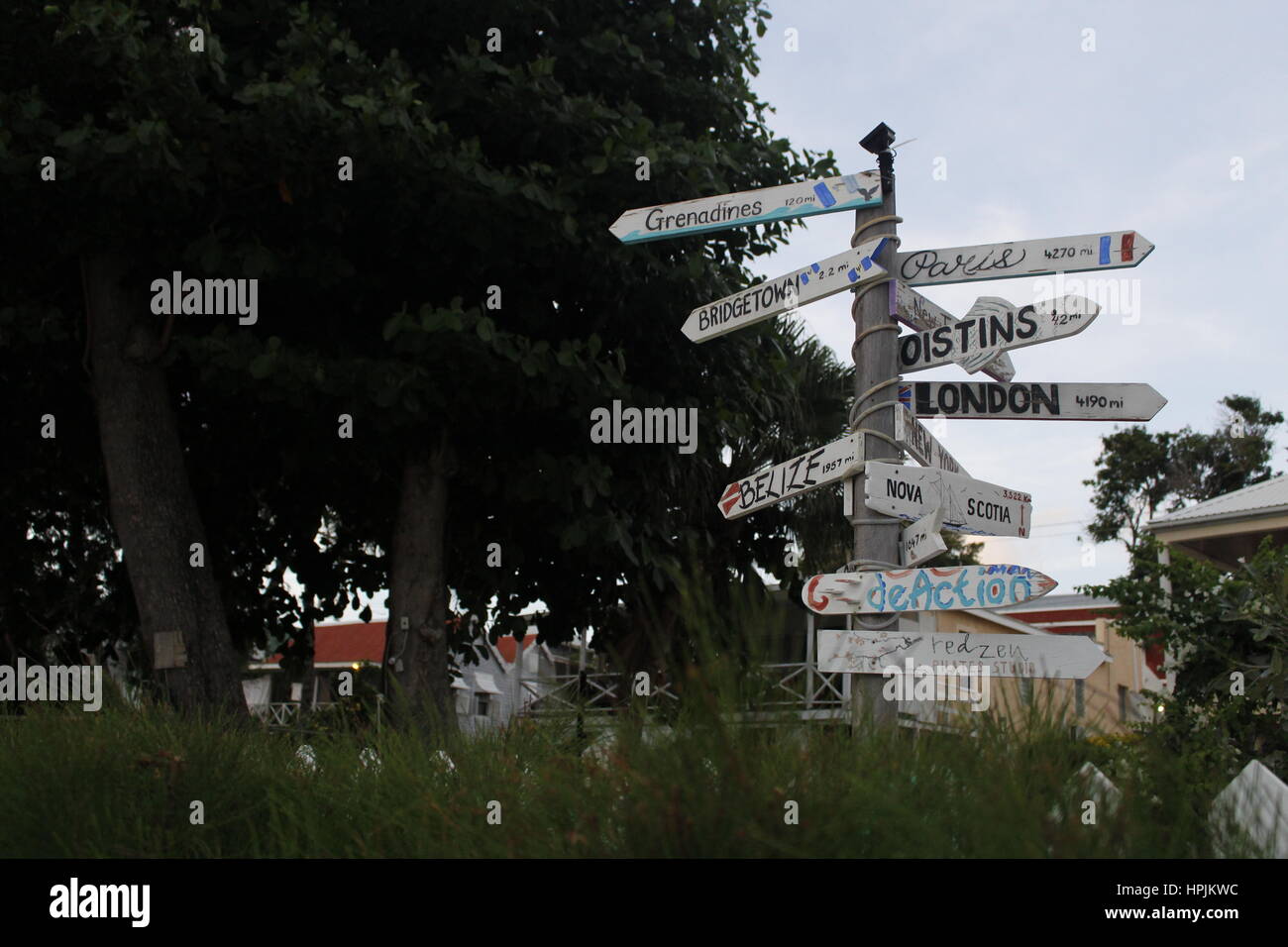 A sign shows the distance in miles to various world destinations on a beach in Hasting, Barbados, Caribbean. Stock Photo