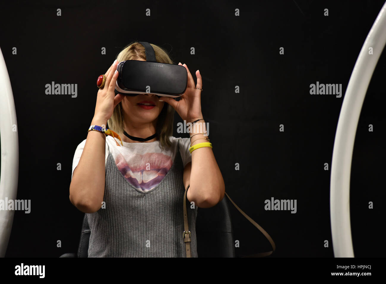 CLUJ-NAPOCA, ROMANIA - AUGUST 7, 2016: Girl tries virtual reality Samsung Gear VR headset and hand controls during the virtual reality exposition, at  Stock Photo