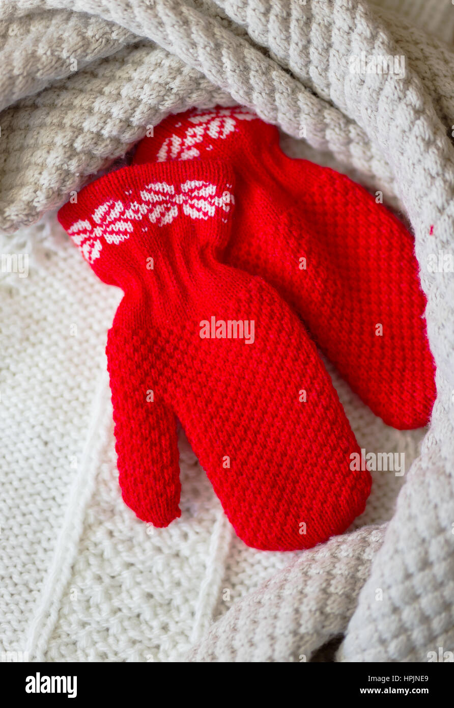 Winter baby clothes, scarf and mittens on wooden background Stock Photo
