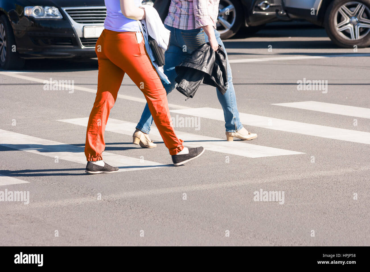 Spring Crosswalk two women pedestrians walking on a crosswalk outside on sunny spring ...
