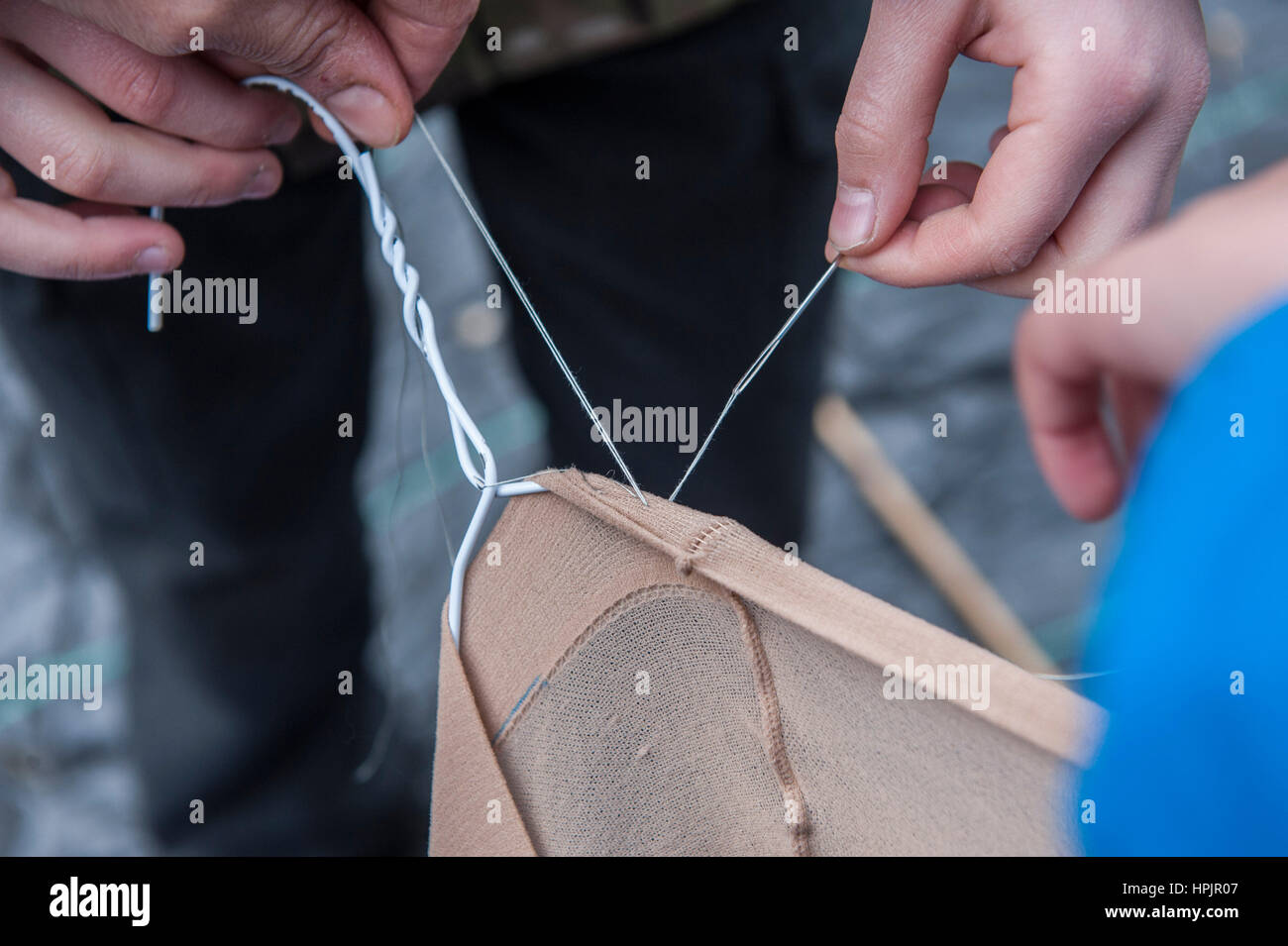 Primary school kids making a pond dipping net out of a womans stocking