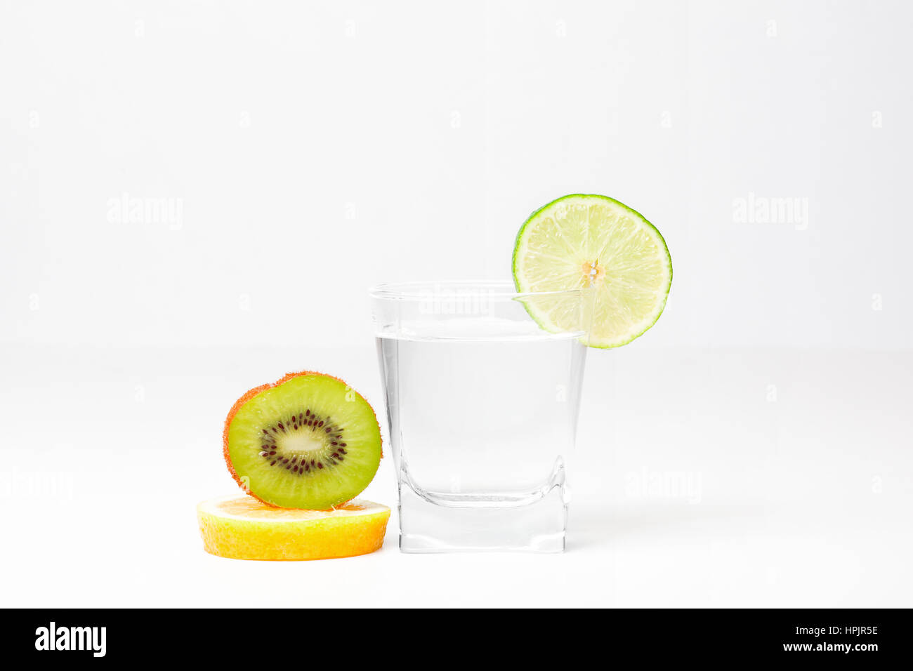 Glass of fresh water, piece of lemon kiwi and lime Stock Photo