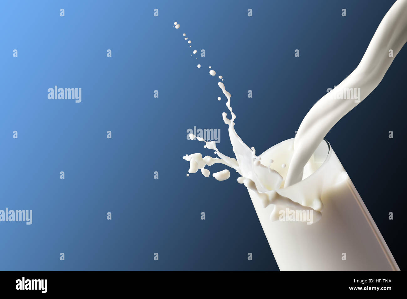 Milk splash in the glass on  blue background Stock Photo