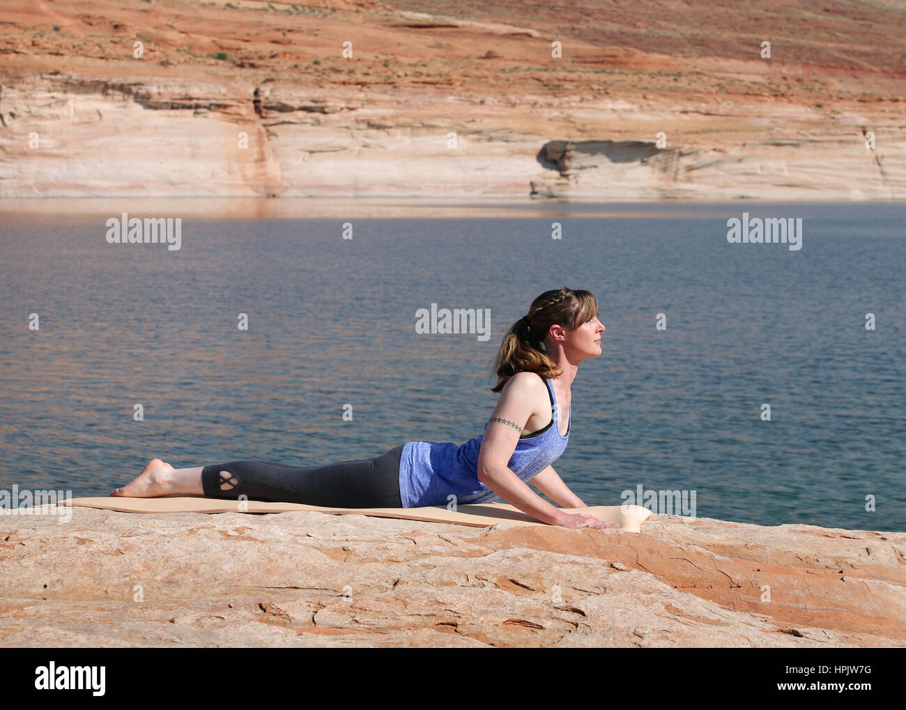 woman practicing yoga by lake Stock Photo