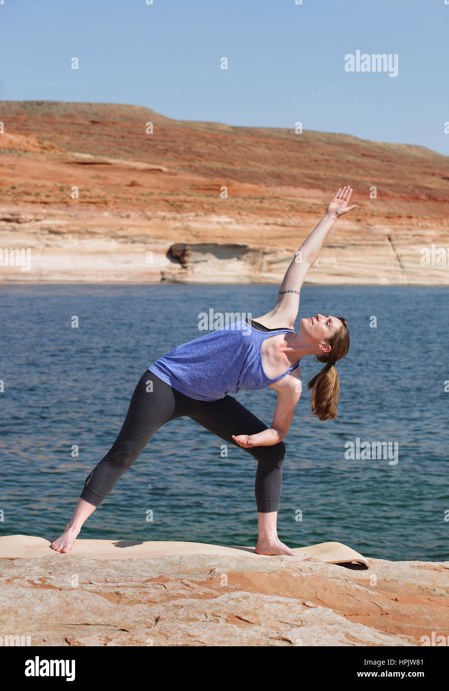 woman practicing yoga by lake Stock Photo