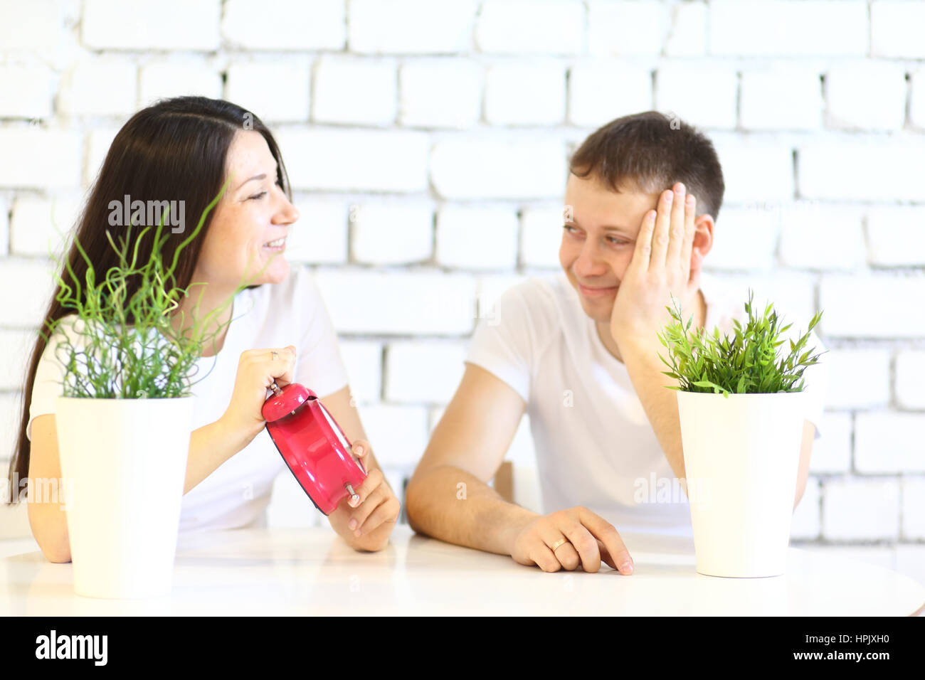Young happy couple in a white t-shirt waiting for good new Stock Photo
