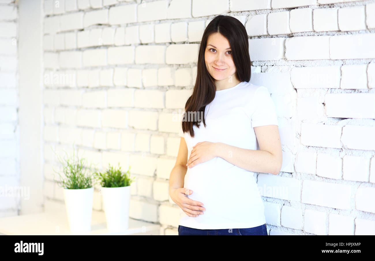 Young smiling pregnant woman on a white break background Stock Photo