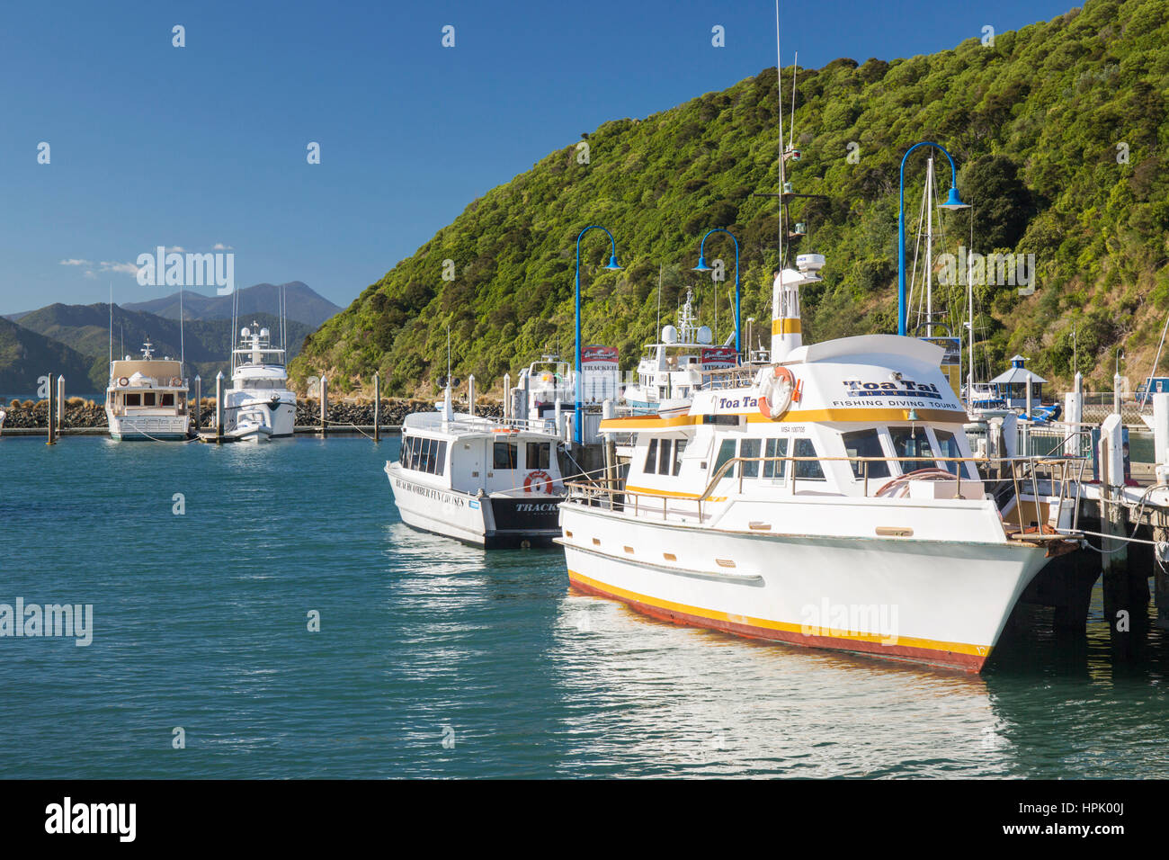 Picton, Marlborough, New Zealand. Boats moored alongside wooden jetty, Picton Harbour. Stock Photo