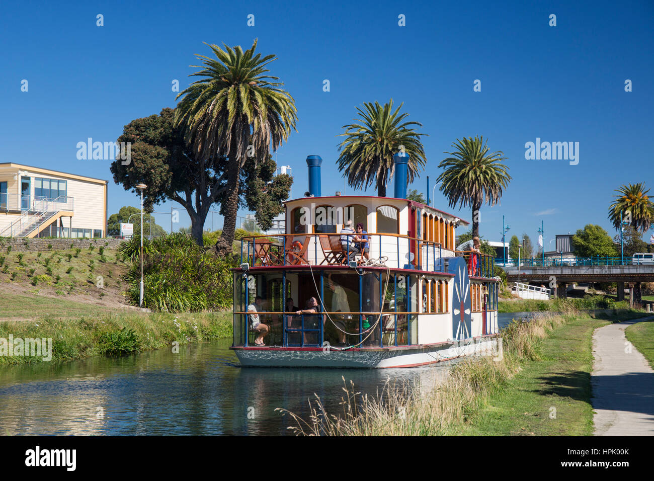 Blenheim, Marlborough, New Zealand. View along the palm-lined Taylor River, Marlborough's River Queen heading downstream. Stock Photo
