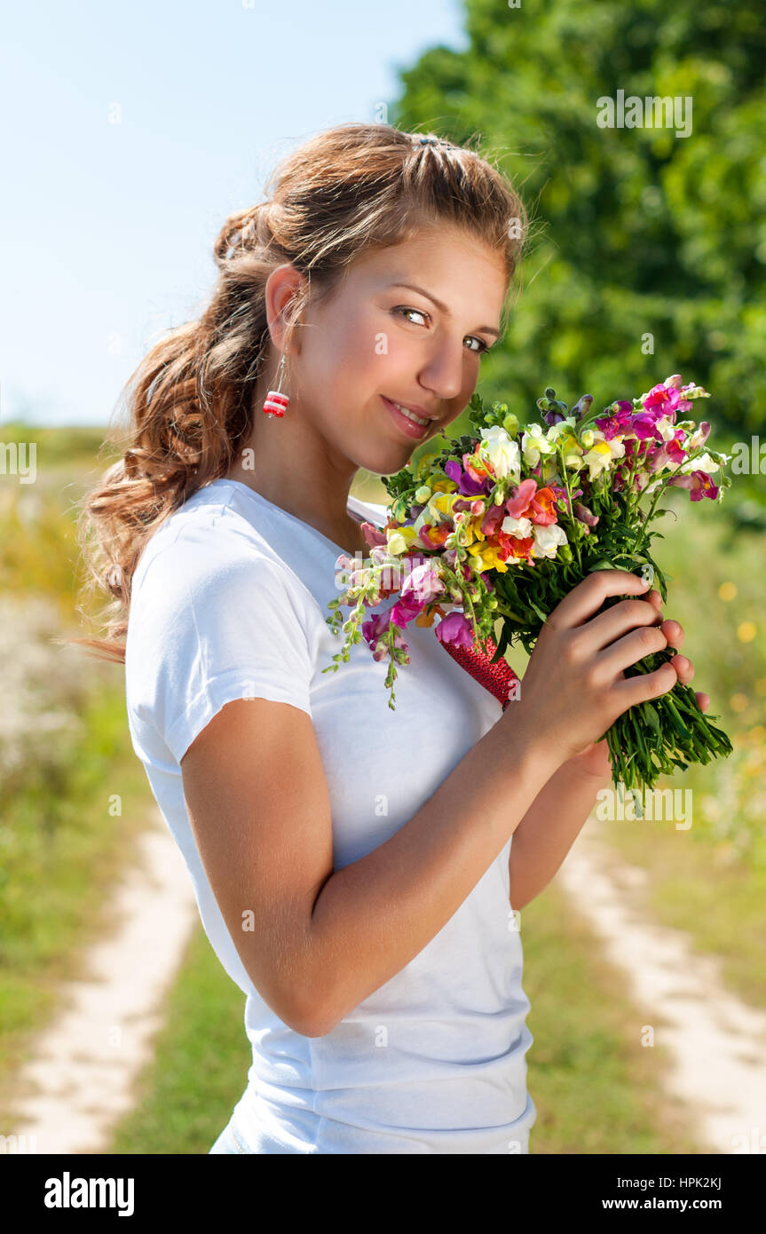 Beautiful blonde girl with a bouquet of wild flowers outdoors Stock ...