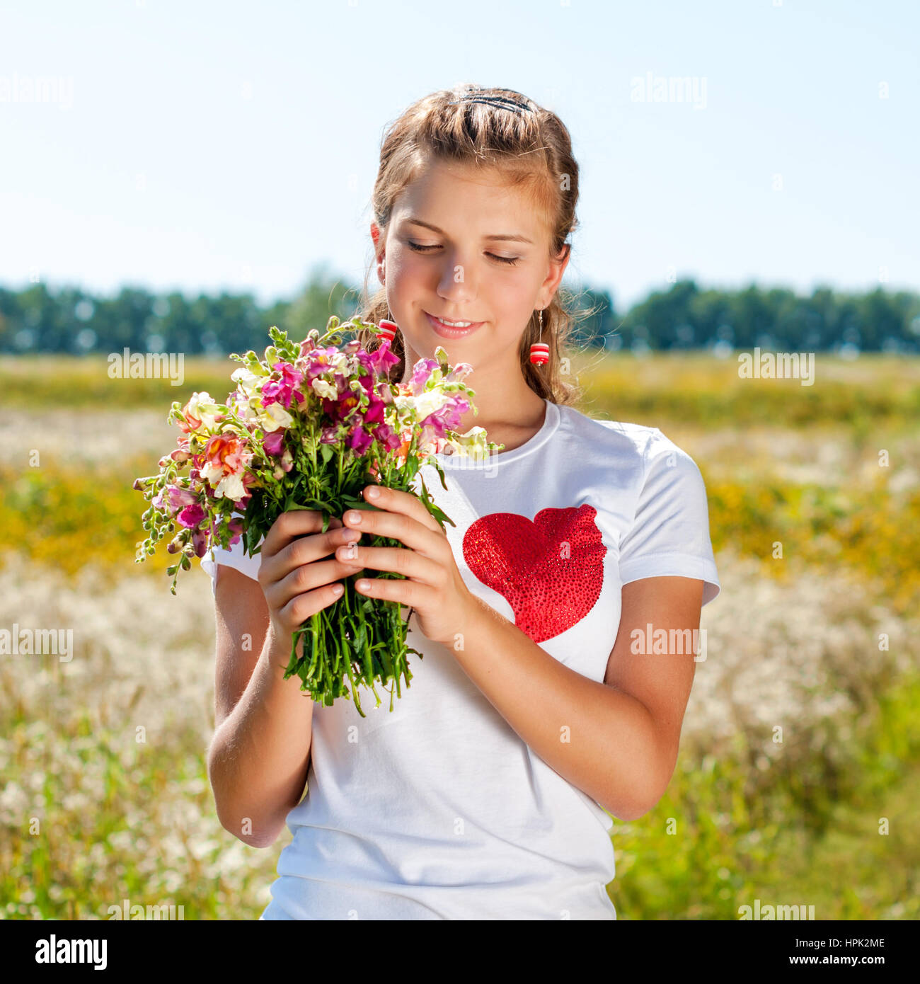 Beautiful blonde girl with a bouquet of wild flowers outdoors Stock ...