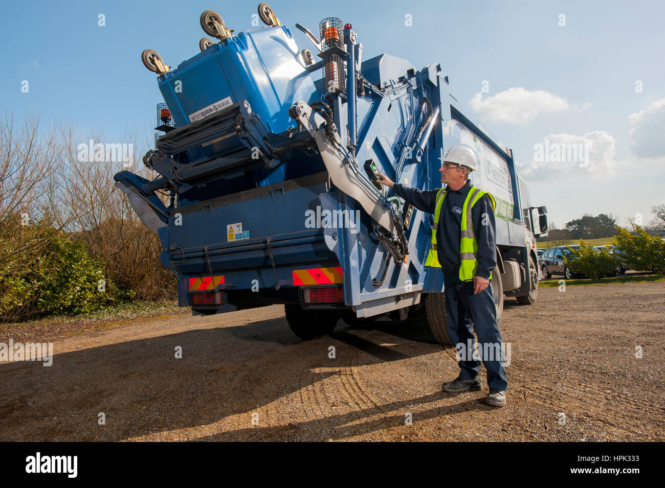 Commercial dustcart operator tipping a dumpster into the truck Stock Photo