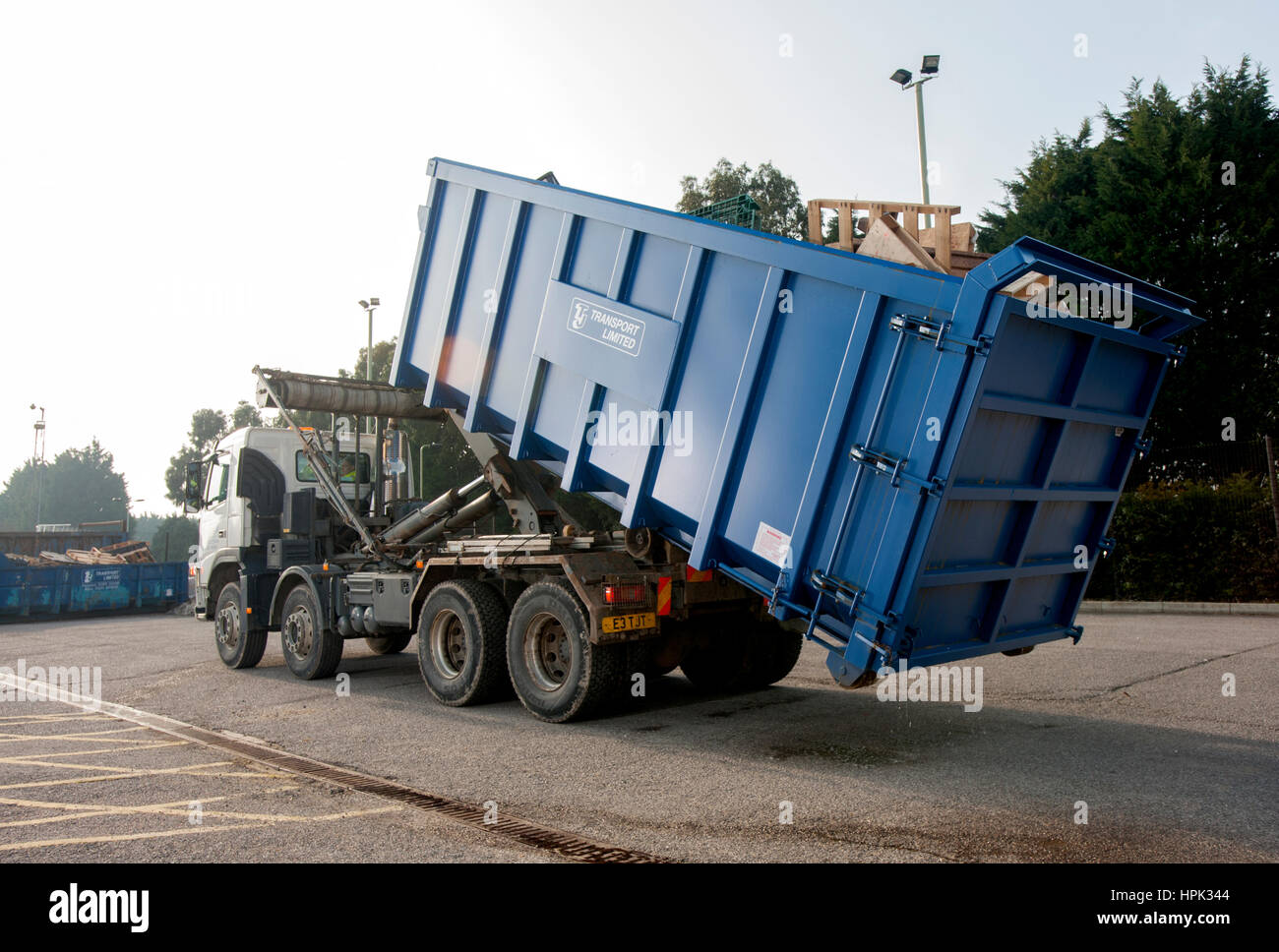 Commercial skip lorry loading a large waste dumpster Stock Photo