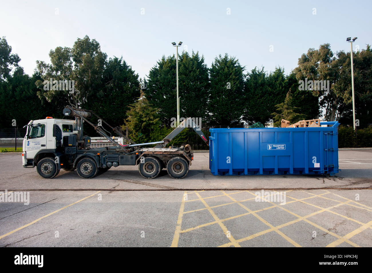 Commercial skip lorry loading a large waste dumpster Stock Photo