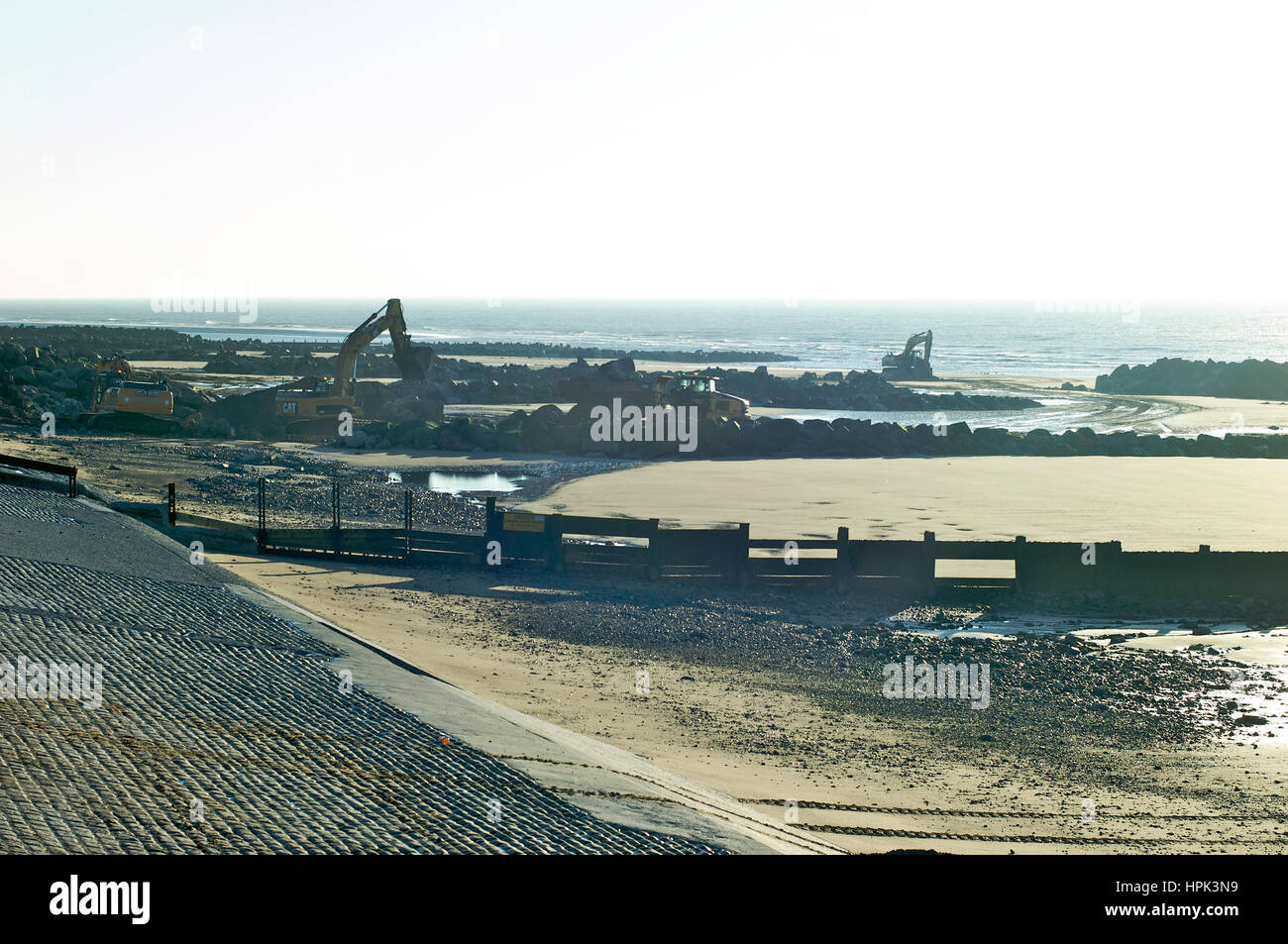 Excavators digging on the beach Stock Photo - Alamy