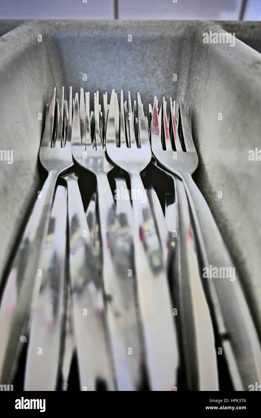 Forks sat in grey plastic tray in restaurant kitchen Stock Photo