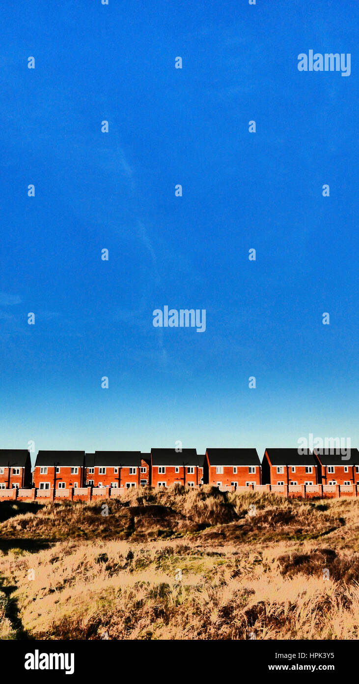 Row of new detached houses against blue sky Stock Photo