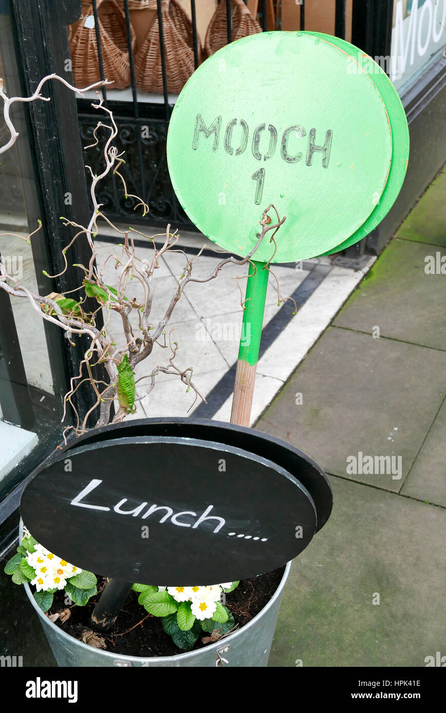 Round wooden signs outside shop inviting people to lunch and mooch Stock Photo