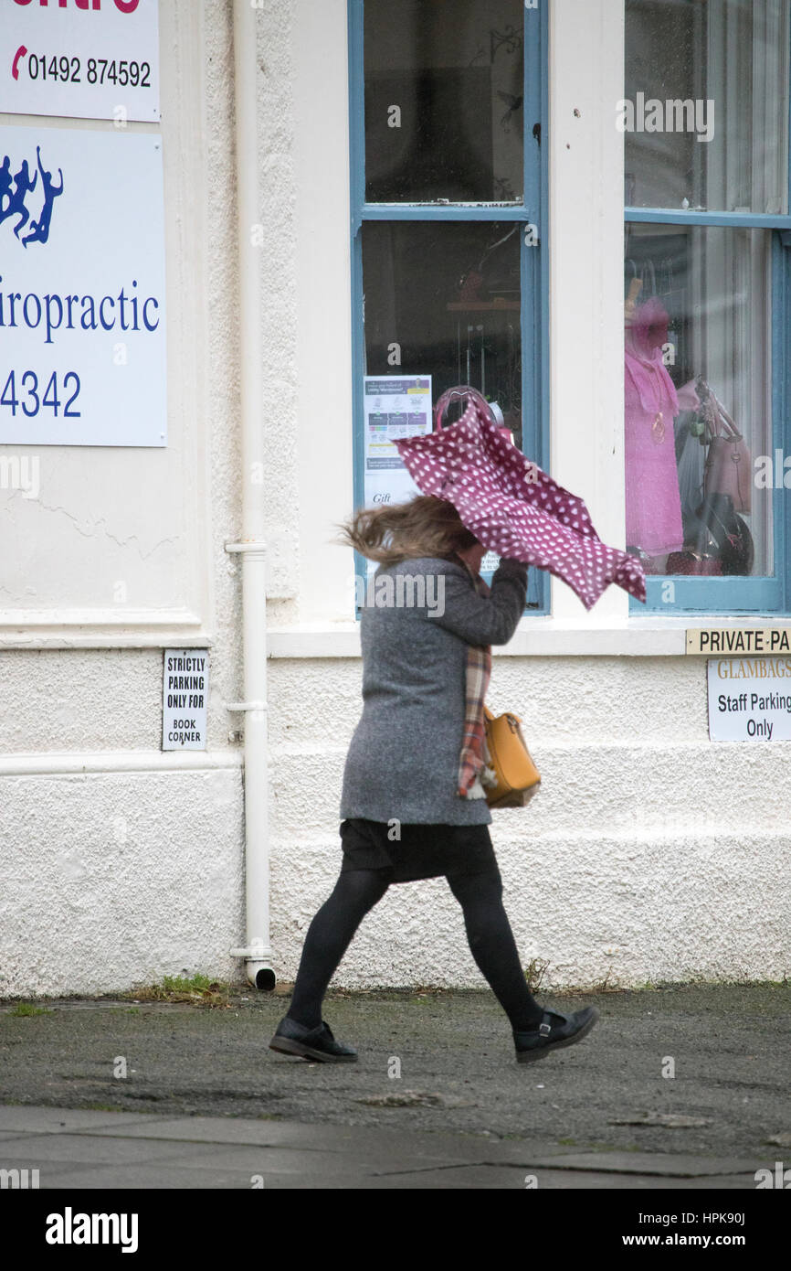 Female commuter walking to work in wet and windy weather as a result of Storm Doris as it hit Llandudno, North Wales Stock Photo