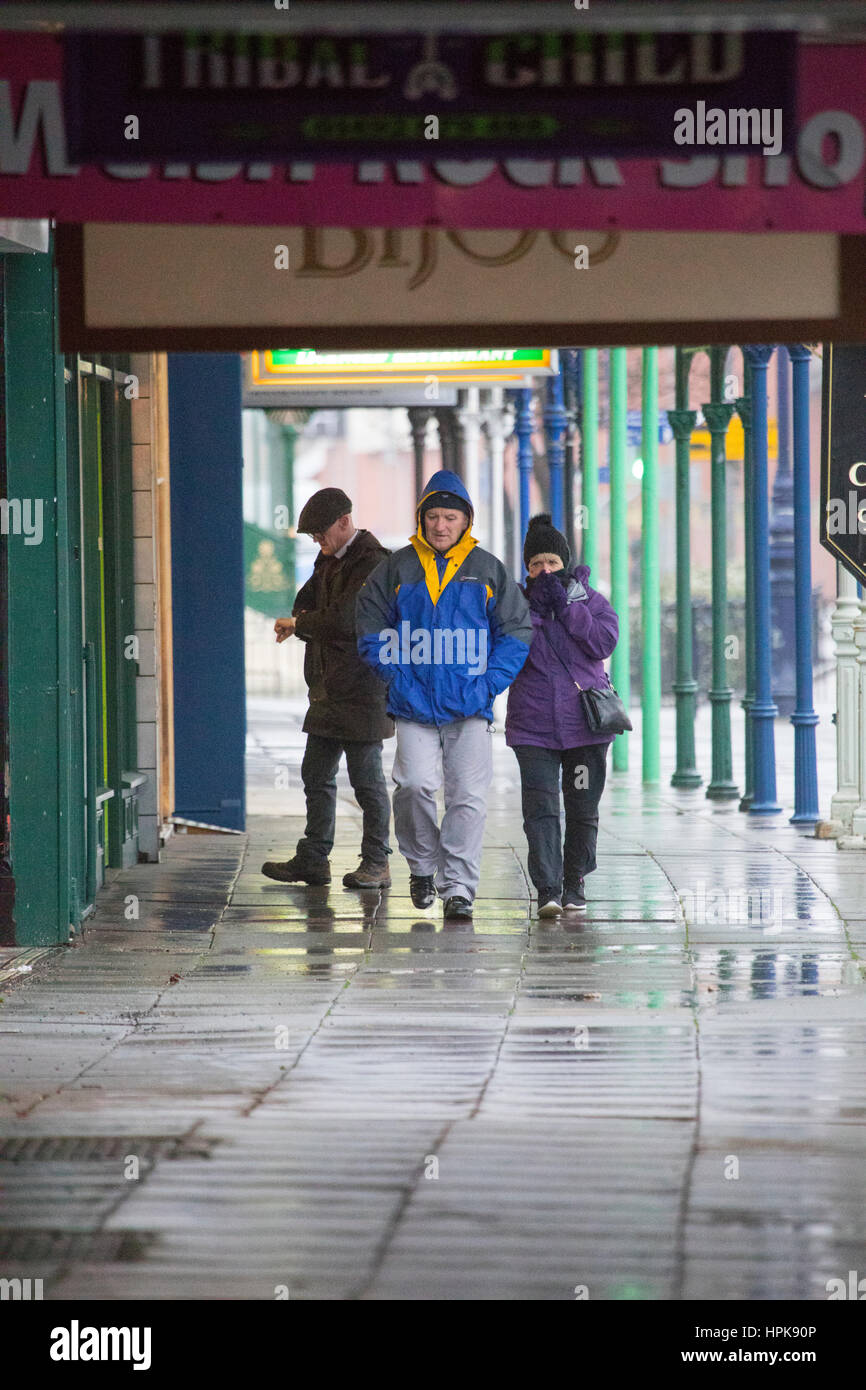 Commuters walking to work in wet and windy weather as a result of Storm Doris as it hit Llandudno, North Wales Stock Photo