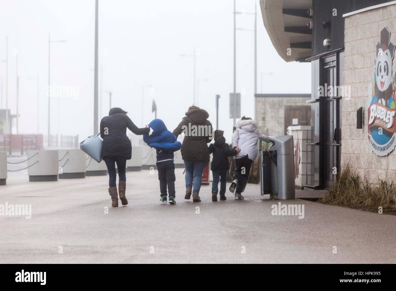 New Brighton, UK. 23rd Feb, 2017. UK Weather. High winds from Storm Doris batter the coastline at New Brighton on the Wirrall in the North West of England today (Thursday 23rd February). Two women and children battle through the wind. Picture by Credit: Chris Bull/Alamy Live News Stock Photo