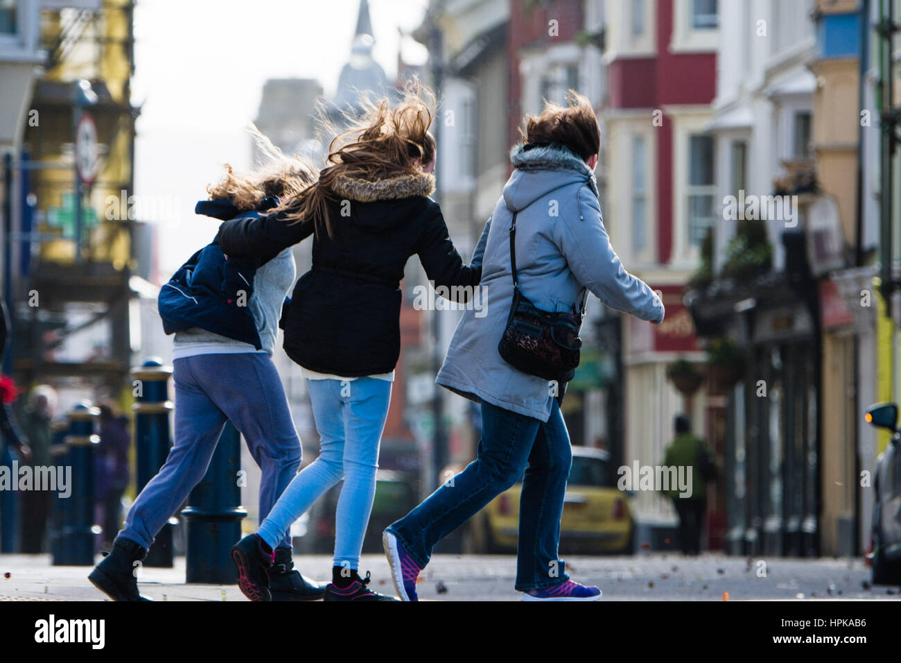 Aberystwyth, Wales, UK. 23rd Feb, 2017. UK Weather: As the winds from Storm Doris strengthen, pedestrians struggle to walk on the streets of Aberystwyth this morning. Violent Storm Force 11 winds, with gusts of up to 90mph are forecast for parts of North Wales and NorthWest England, with the risk of damage to property and severe disruption to travel Storm Doris is the fourth named storm of the winter, and has been classified as a ‘weather bomb' (explosive cyclogenesis) by the Met Office Photo Credit: Keith Morris /Alamy Live News Stock Photo