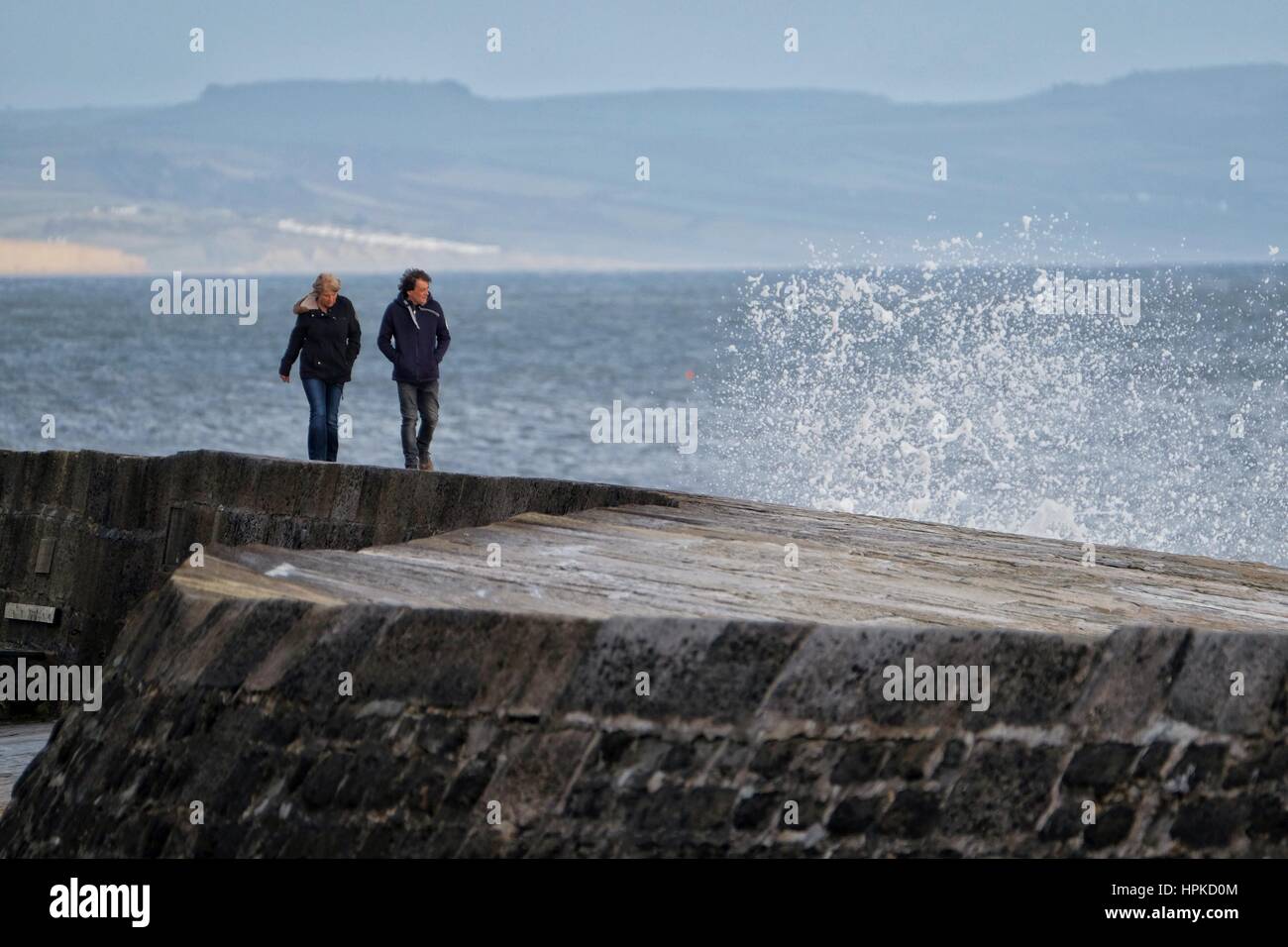 Lyme Regis, Dorset, UK. 23rd Feb, 2017. UK Weather. Waves break the Cobb at Lyme Regis as as people watch Storm Doris hits the Dorset Coast. Winds of 50 to 60mph are expected during the day with coastal areas being particularly vulnerable. Credit: Tom Corban/Alamy Live News Stock Photo