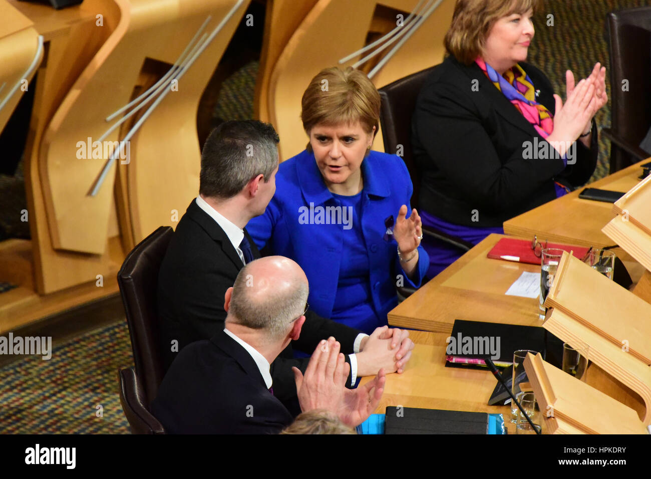 Edinburgh, Scotland, United Kingdom. 23rd February, 2017. First Minister Nicola Sturgeon (C) congratulates Finance Secretary Derek Mackay (L) as the Stage Three and final debate on the Scottish budget is carried by the Government, Credit: Ken Jack/Alamy Live News Stock Photo
