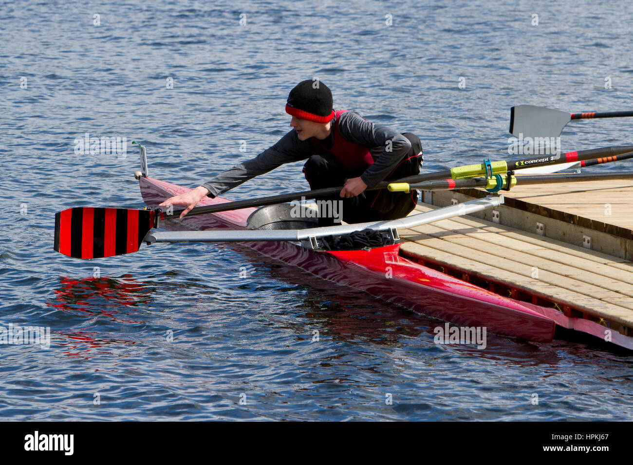Teenage Rower A teenage rower sportsman, removing the oars alongside his boat ...