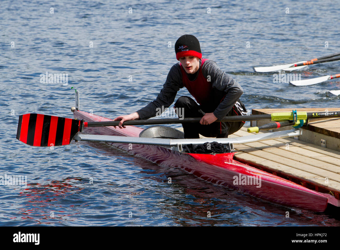 Teenage Rower A teenage rower sportsman, removing the oars alongside his boat ...