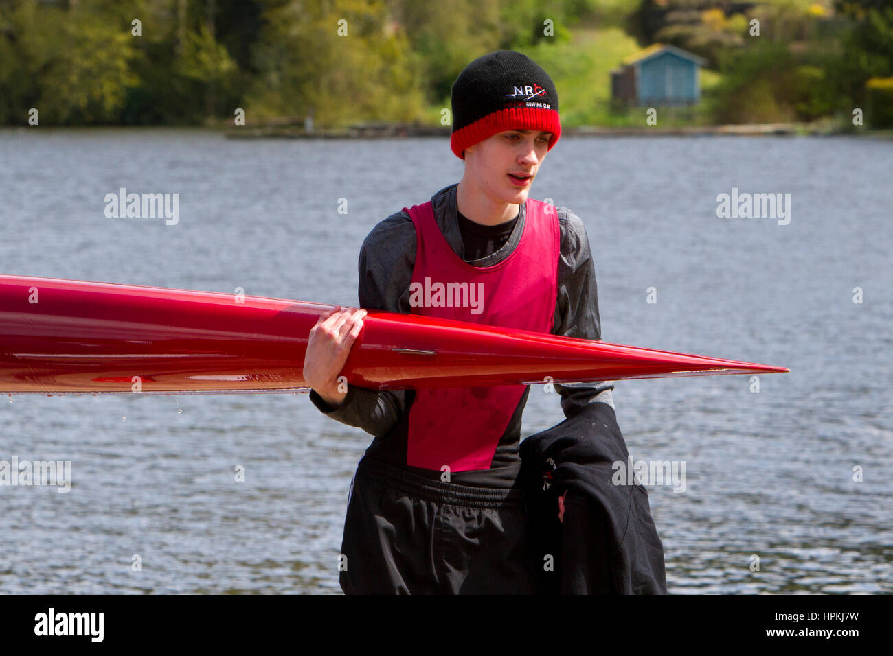 Teenage Rower A teenage rower sportsman, carrying a singles rowing boat following a ...