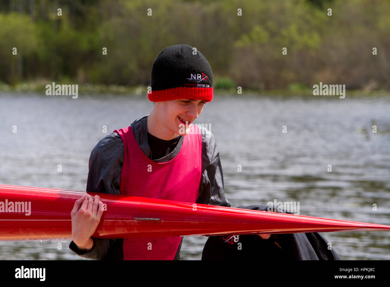 Teenage Rower A teenage rower sportsman, carrying a singles rowing boat following a ...