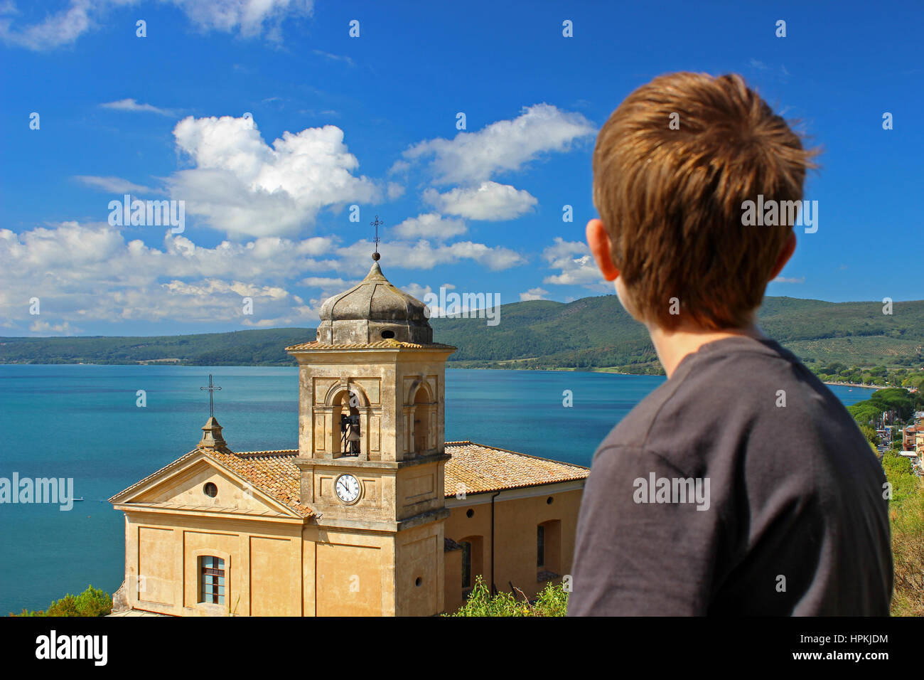 A young man is looking a landscape with the Main Church of Trevigano Romano, a very nice and little village on the Bracciano Lake, near Rome Stock Photo