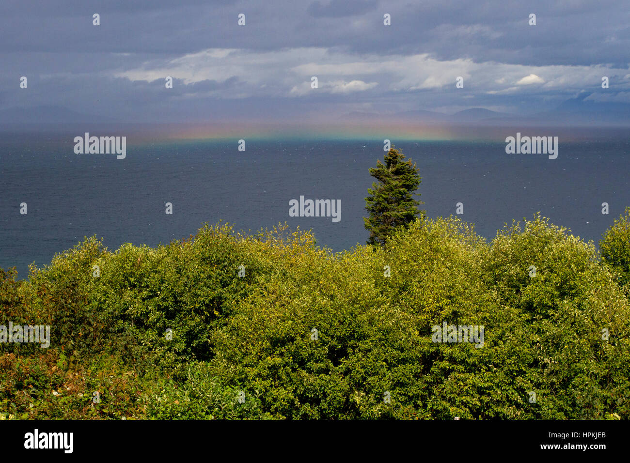 Horizontal rainbow over the Strait of Georgia from north Nanaimo, BC, Canada Stock Photo