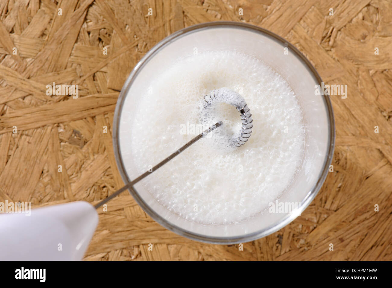 making foamy milk with milk frother, home cooking Stock Photo Alamy