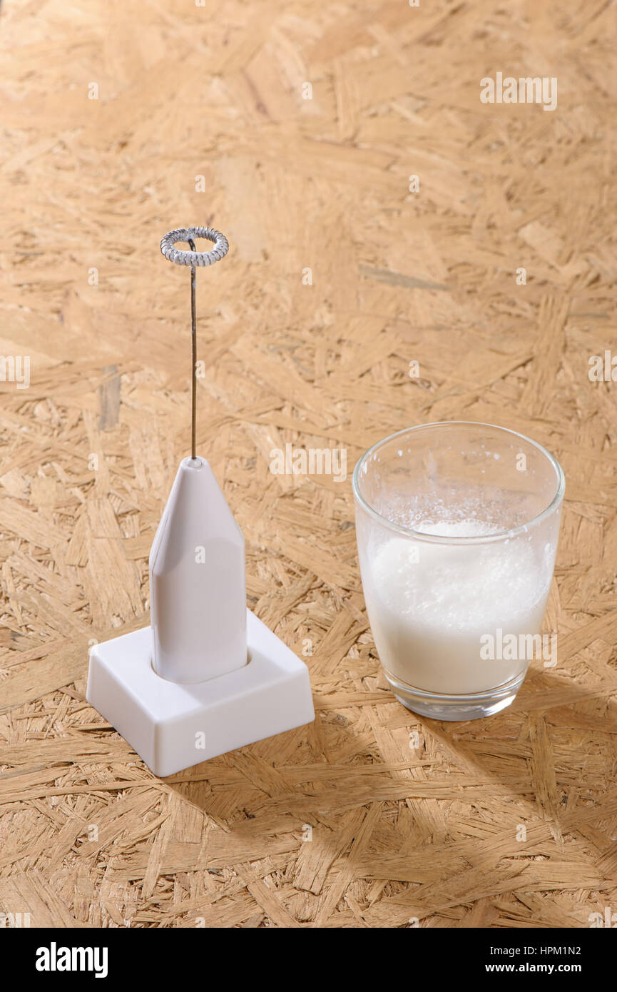 making foamy milk with milk frother, home cooking Stock Photo Alamy