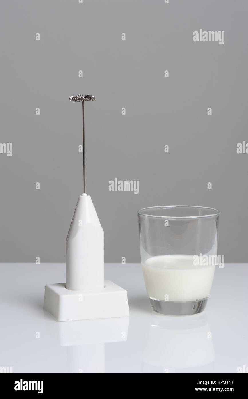 closeup milk frother and half cup of milk Stock Photo Alamy