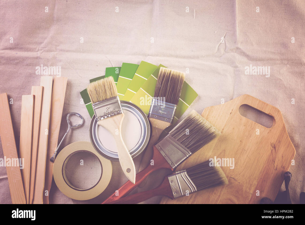 Paint in metal paint can and painters tools on a canvas drop cloth