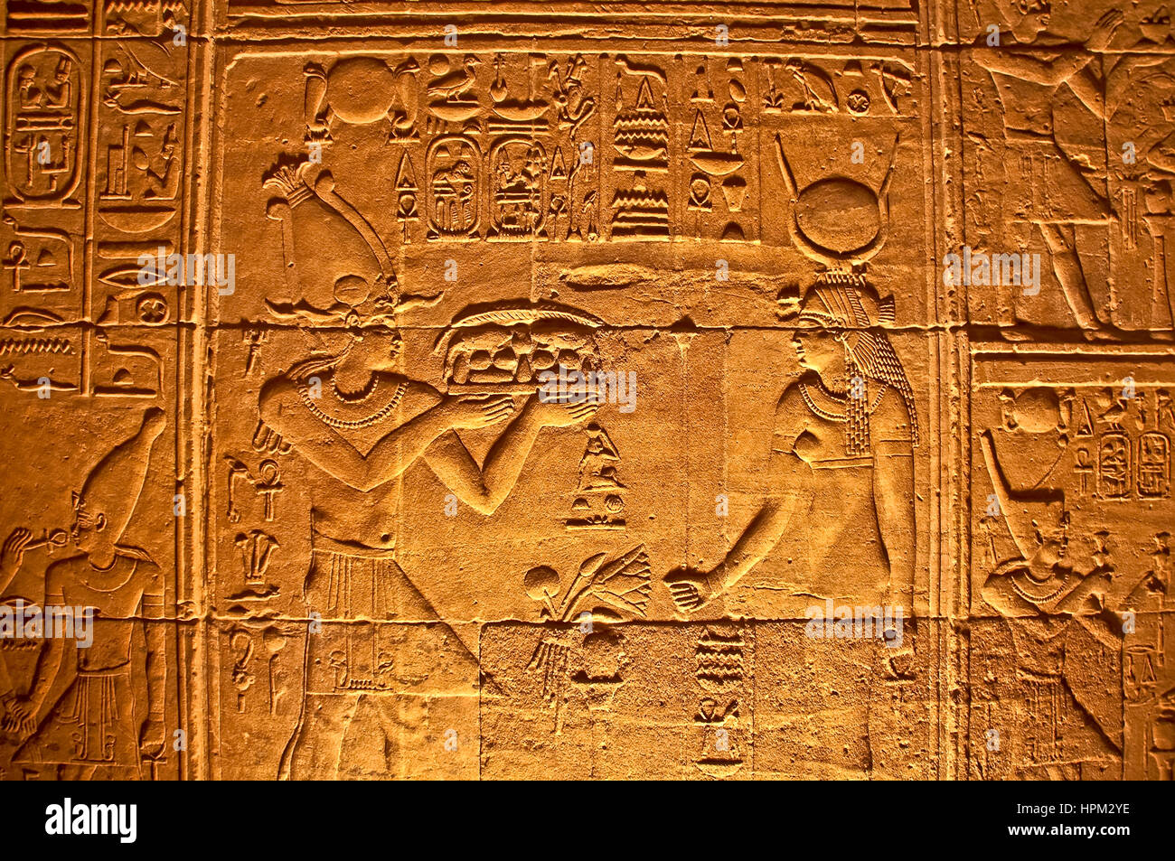 Illuminated wall showing offering being made by gods at Philae Temple, or Temple of Isis at Philae Island Stock Photo