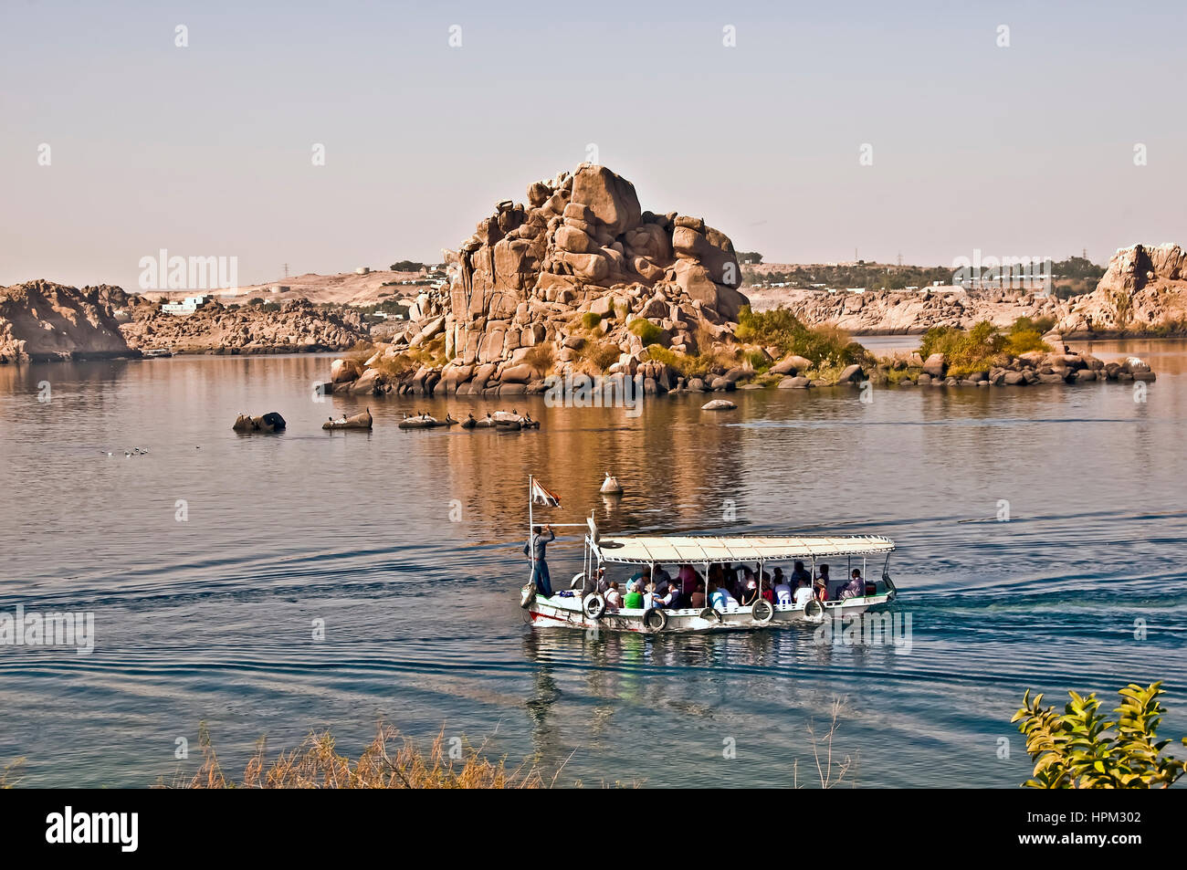 Tour boat ferry carrying passengers to Philae Temple, or Temple of Isis on Philae Island Aswan Stock Photo