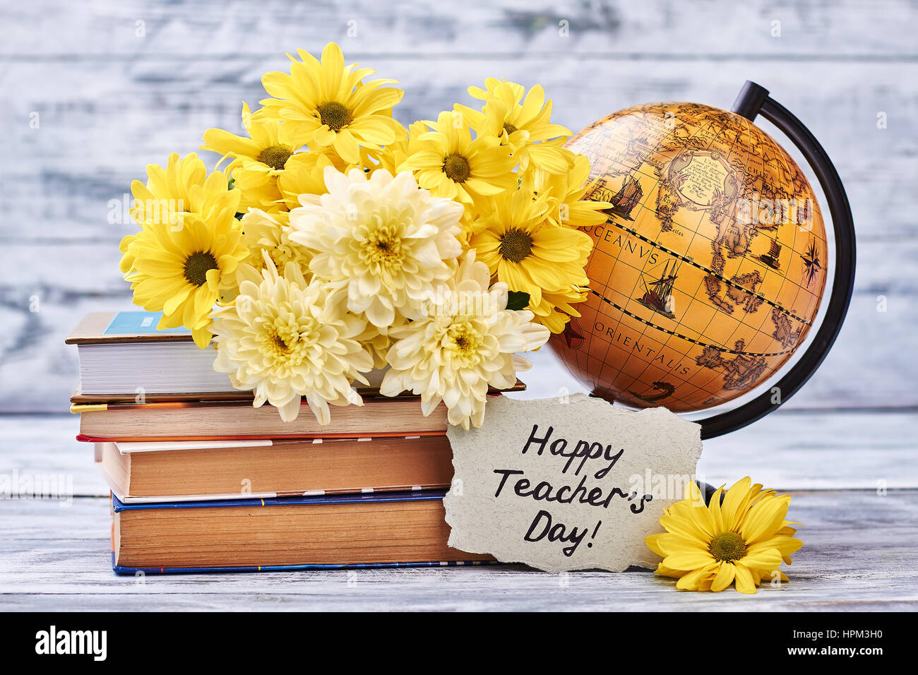 Yellow chrysanthemums, books and globe. Stock Photo