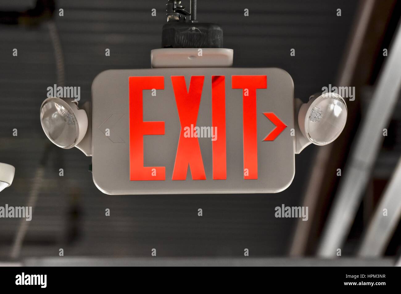 Emergency exit sign in hallway of building Stock Photo